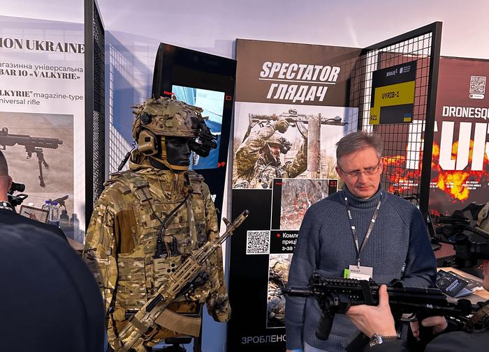 Soldier alongside drone systems at a defense exhibition